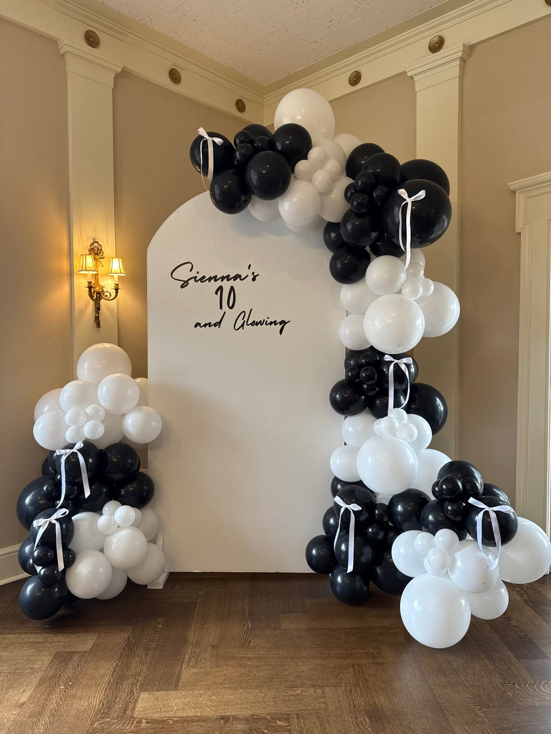 Black-and-white balloon garland on a white arch backdrop at a Pittsburgh birthday party by Party on Butler
